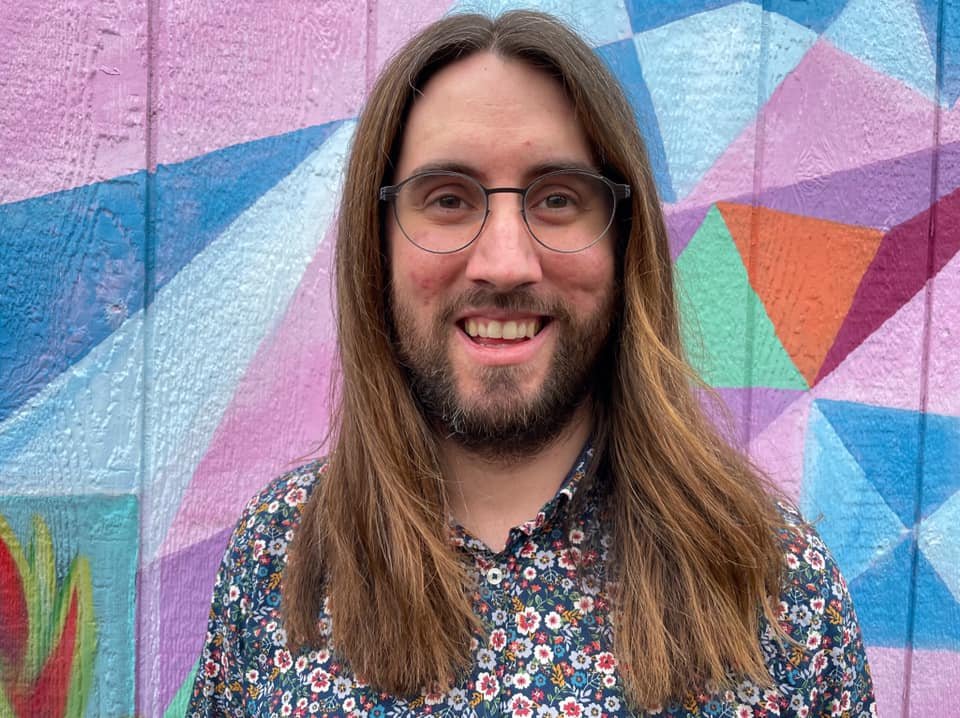 Ted in front of a colorful mural